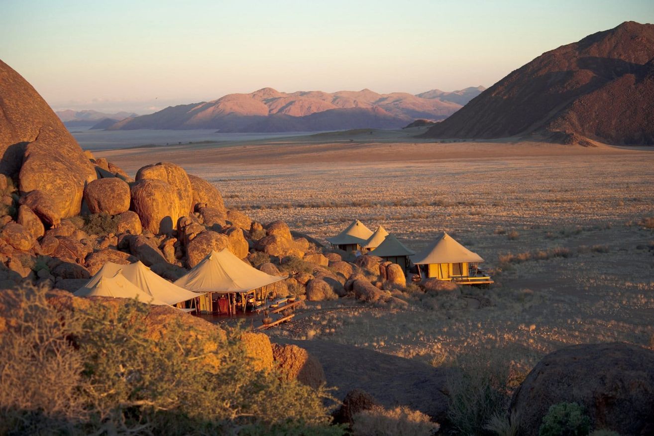 Luxury tented camp in the Namibian desert at golden hour